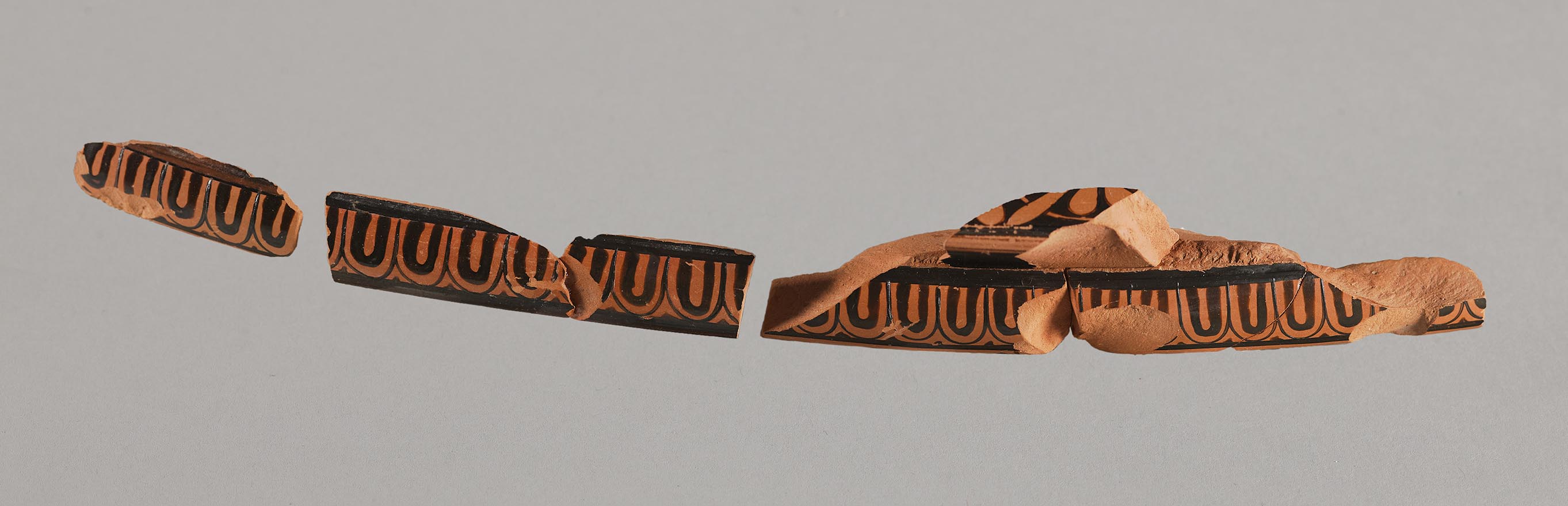 Fragments reconstructed to form the rim of a vase, showing painted decoration