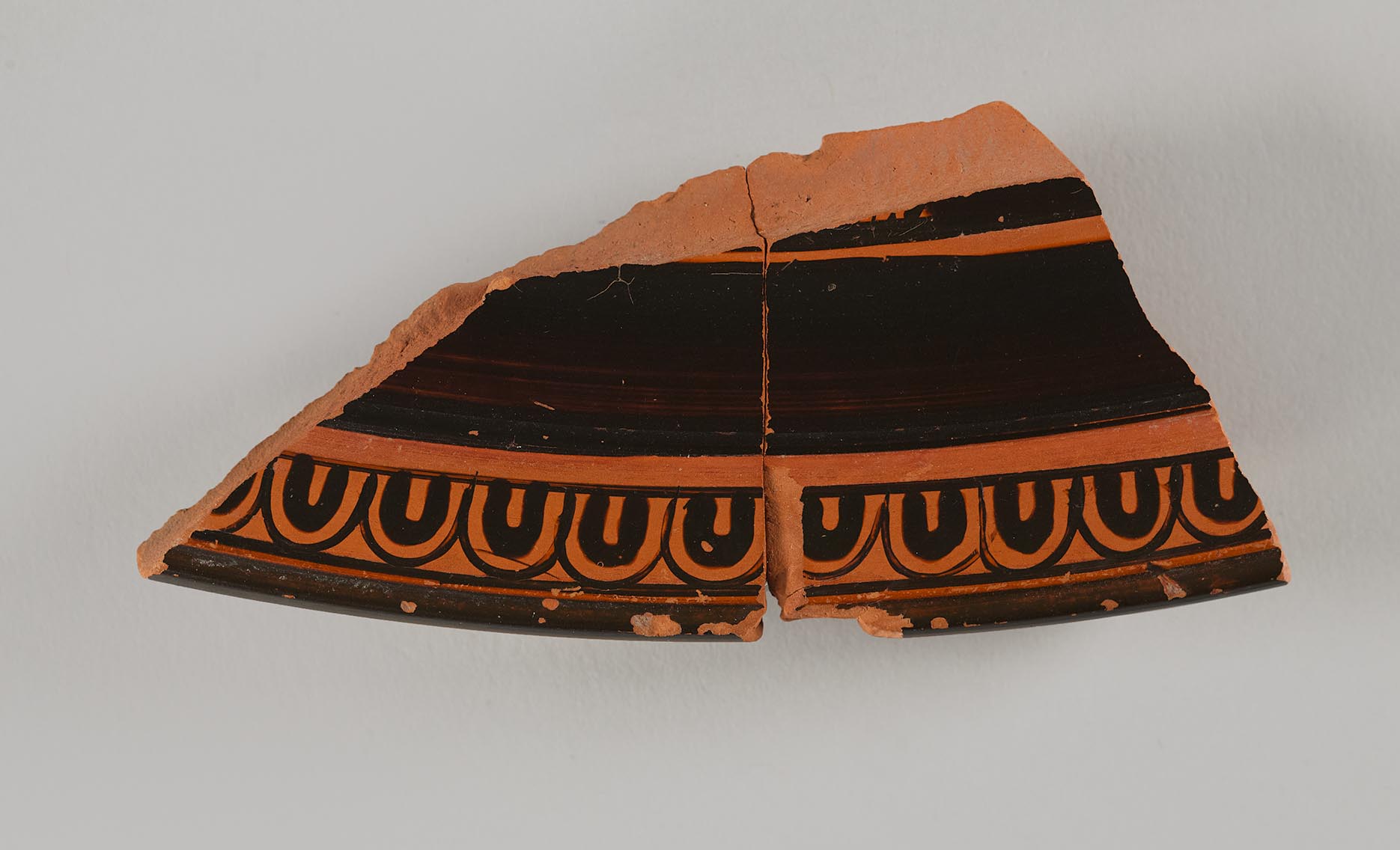 One fragment from the lid of a vase, showing painted decoration