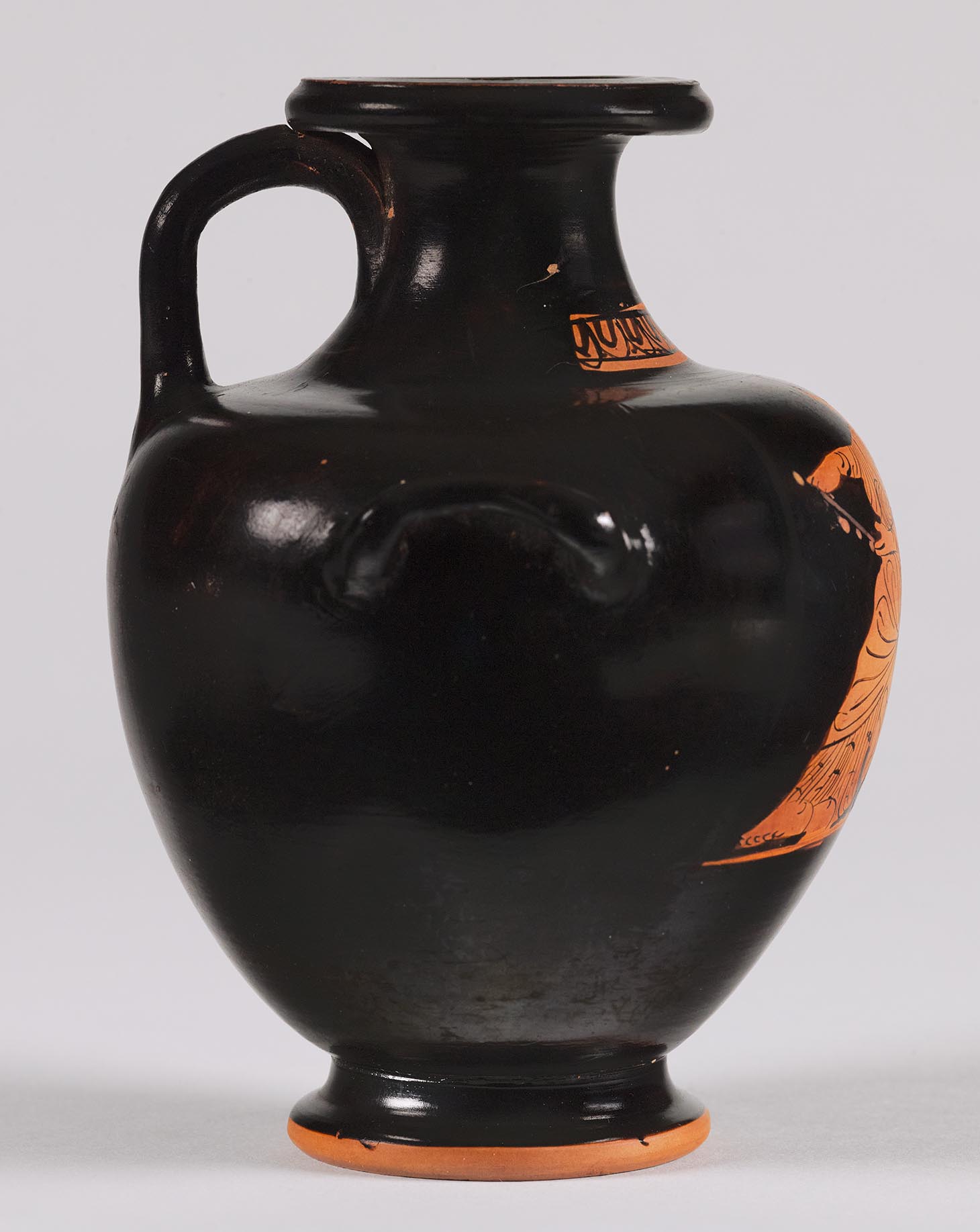 The other side of the vase, showing some decoration and a partial figure on the left side