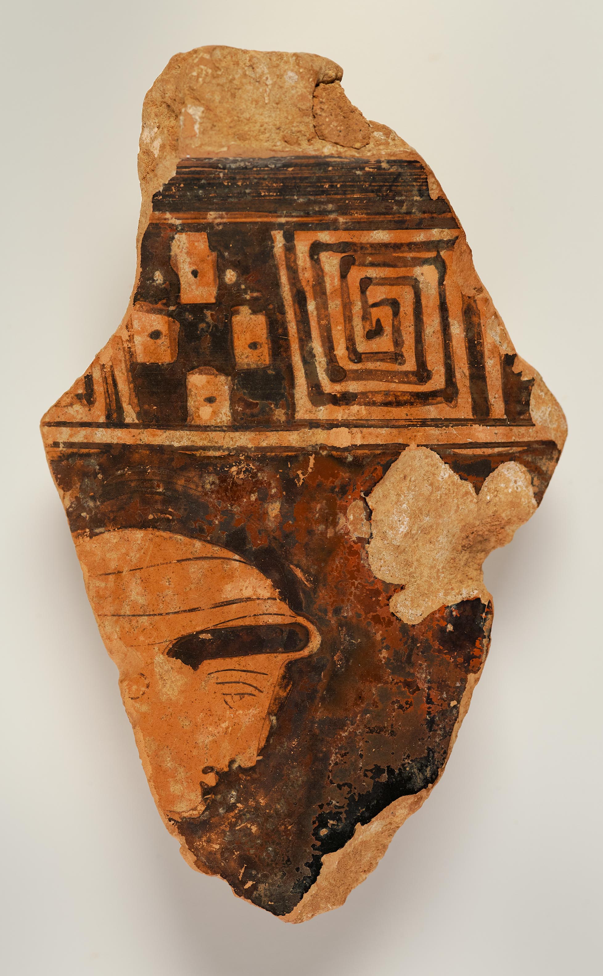 A vase fragment depicting the head of a woman below a decorative band